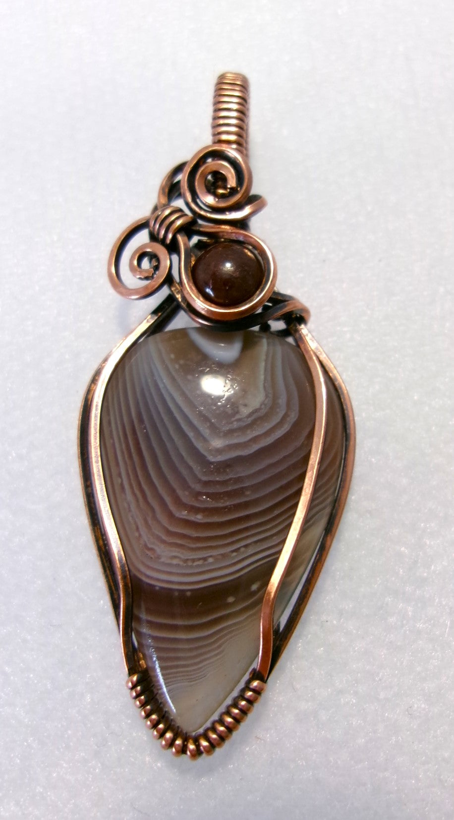 Botswana Agate gemstone copper wire wrapped crystal pendant with garnet accent bead and 2 spirals