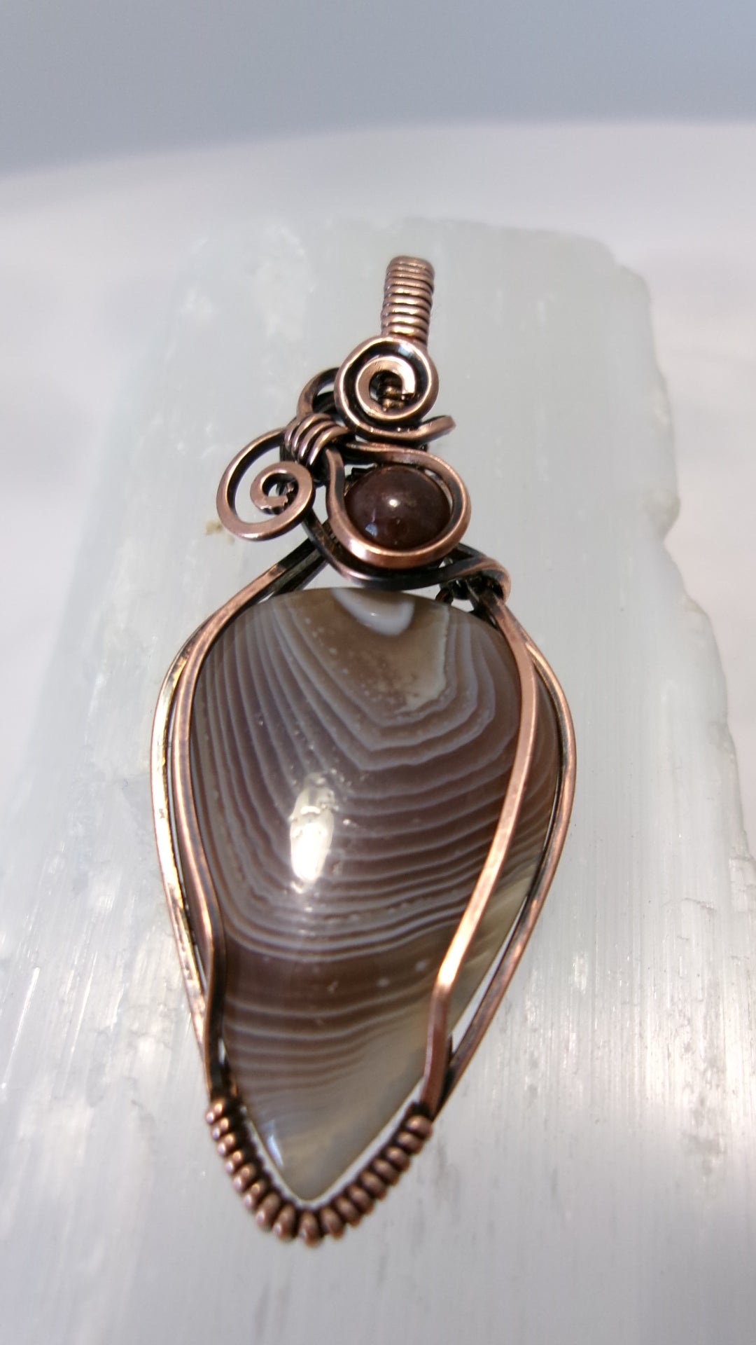 Botswana Agate gemstone copper wire wrapped crystal pendant with garnet accent bead and 2 spirals