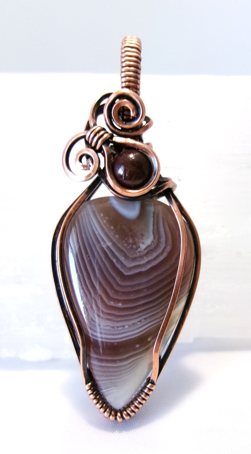 Botswana Agate gemstone copper wire wrapped crystal pendant with garnet accent bead and 2 spirals