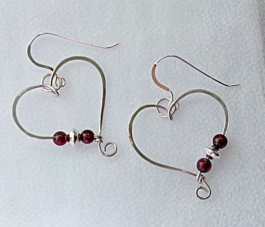 Red garnet sterling silver wire earrings in a heart shape design with a tiny spiral