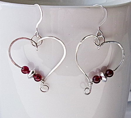 Red garnet sterling silver wire earrings in a heart shape design with a tiny spiral