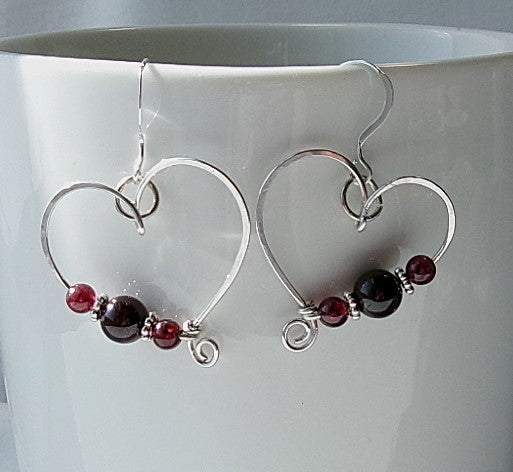 Red garnet sterling silver wire earrings in a heart shape design with a tiny spiral