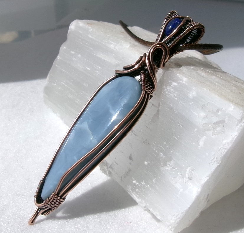 Owyhee Blue Opal gemstone copper wire wrapped crystal pendant with lapis lazuli gemstone set in a woven bail