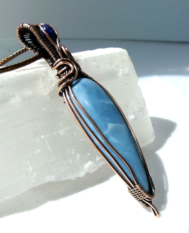 Owyhee Blue Opal gemstone copper wire wrapped crystal pendant with lapis lazuli gemstone set in a woven bail