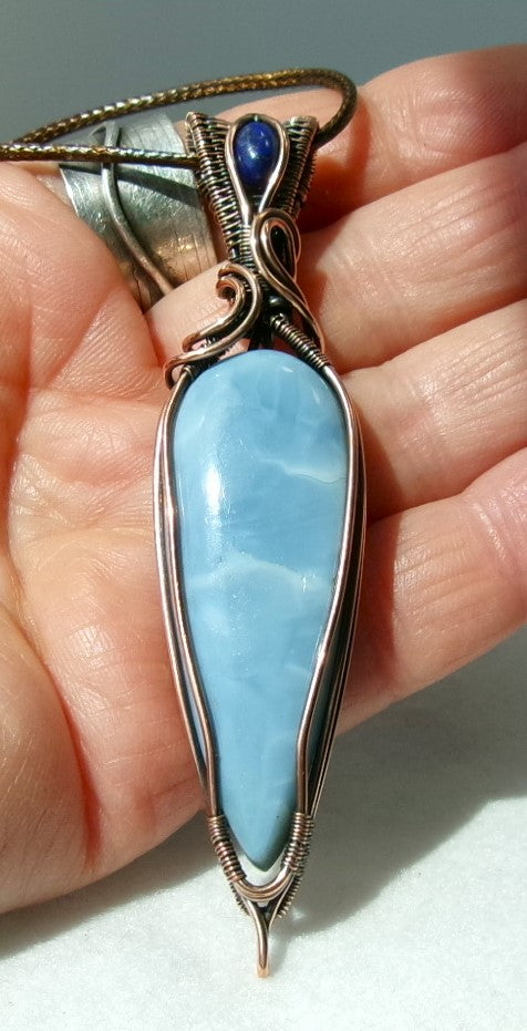 Owyhee Blue Opal gemstone copper wire wrapped crystal pendant with lapis lazuli gemstone set in a woven bail