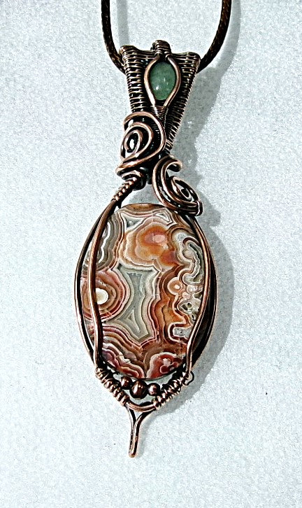 Crazy Lace Agate gemstone copper wire wrapped crystal pendant with a green aventurine gemstone set in a woven bail with copper accent beads
