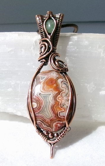 Crazy Lace Agate gemstone copper wire wrapped crystal pendant with a green aventurine gemstone set in a woven bail with copper accent beads