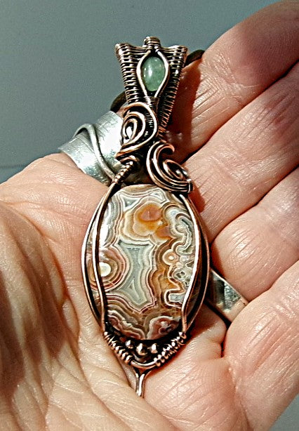 Crazy Lace Agate gemstone copper wire wrapped crystal pendant with a green aventurine gemstone set in a woven bail with copper accent beads