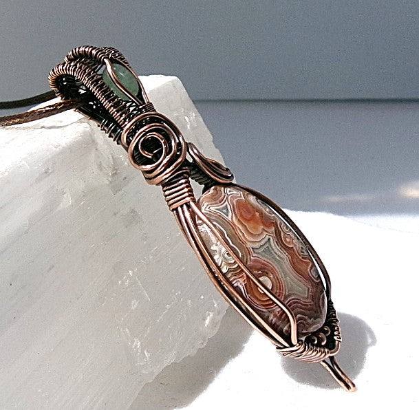 Crazy Lace Agate gemstone copper wire wrapped crystal pendant with a green aventurine gemstone set in a woven bail with copper accent beads