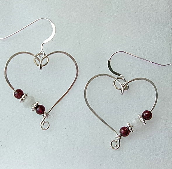 Red garnet and moonstone sterling silver wire earrings in a heart shape design with a tiny spiral