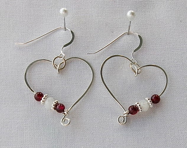 Red garnet and moonstone sterling silver wire earrings in a heart shape design with a tiny spiral