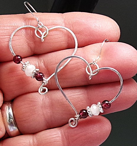 Red garnet and moonstone sterling silver wire earrings in a heart shape design with a tiny spiral